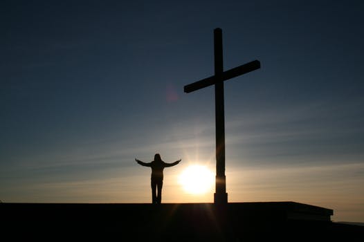 person standing by a cross religion